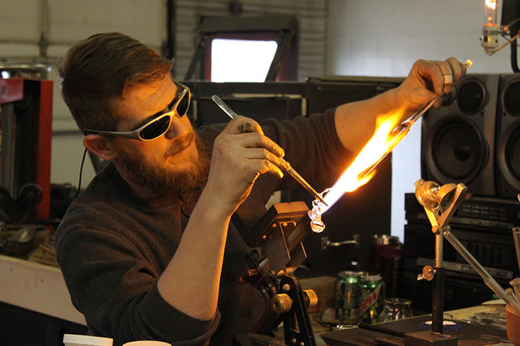 Chad Christensen melting glass with his torch.