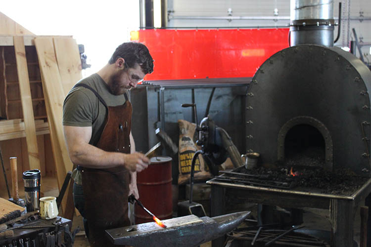 Paul Nyborg, blacksmith, shaping steel on his anvil.