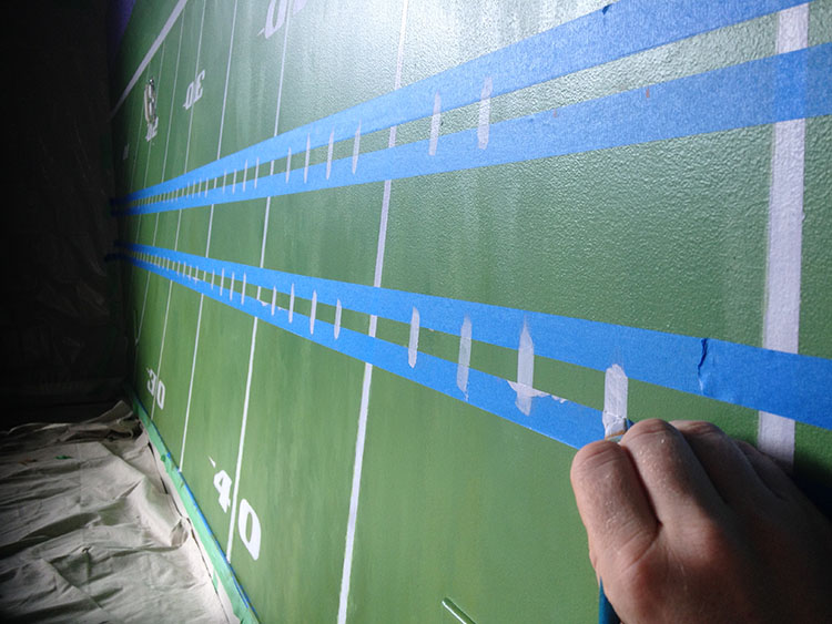 Carefully painting in the hash marks, with masking tape as a straight line to keep the edges sharp.